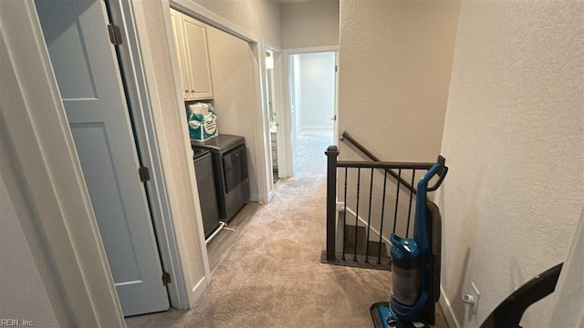 corridor featuring independent washer and dryer and light colored carpet