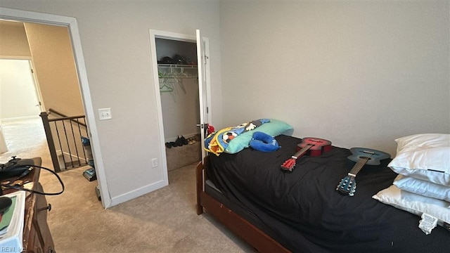 bedroom with a walk in closet, light carpet, and a closet