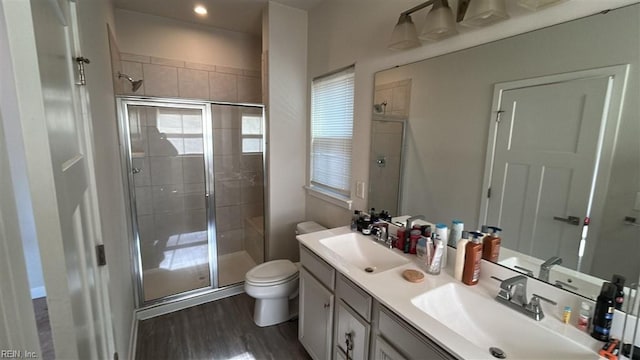 bathroom with hardwood / wood-style flooring, vanity, walk in shower, and toilet