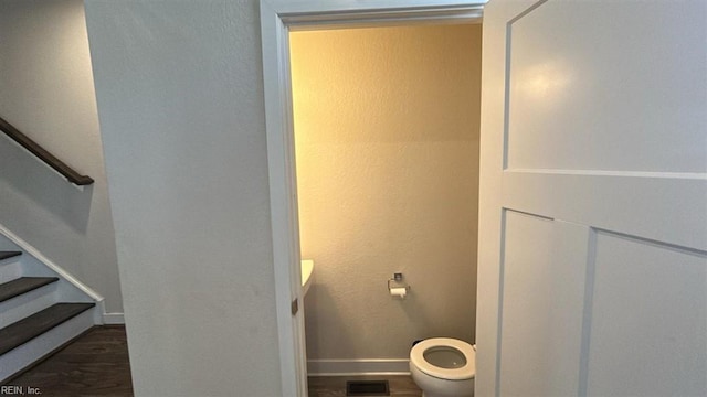 bathroom with wood-type flooring, toilet, and vanity