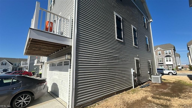 view of side of property with a garage and central air condition unit