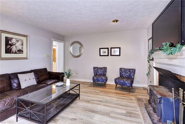 living room with a textured ceiling and light hardwood / wood-style flooring