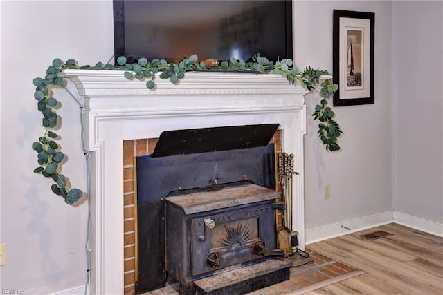 room details featuring a wood stove and hardwood / wood-style floors