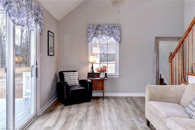 living area featuring vaulted ceiling and light hardwood / wood-style floors