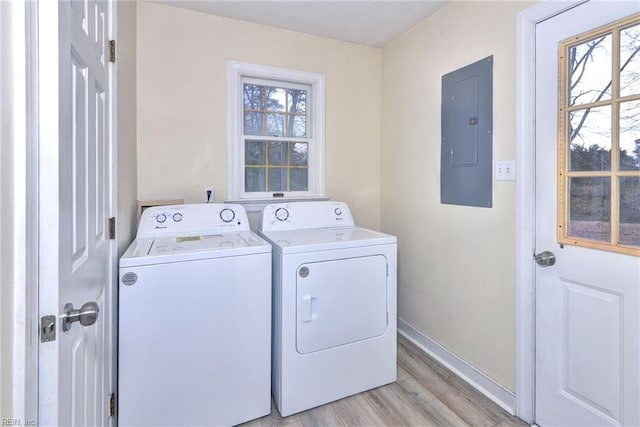 laundry area featuring washing machine and dryer, electric panel, and light hardwood / wood-style floors