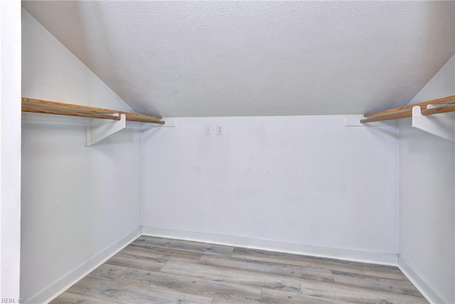 walk in closet featuring lofted ceiling and light hardwood / wood-style floors