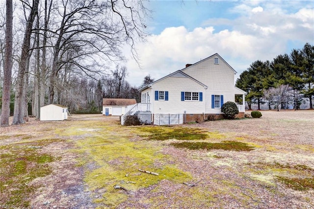 view of home's exterior featuring a lawn and a storage shed