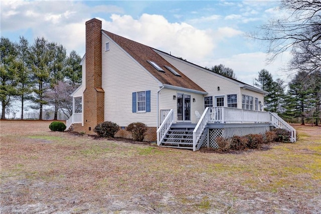 view of front facade with a wooden deck and a front yard