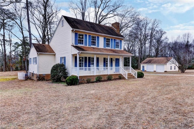 colonial-style house featuring an outbuilding, a garage, and covered porch