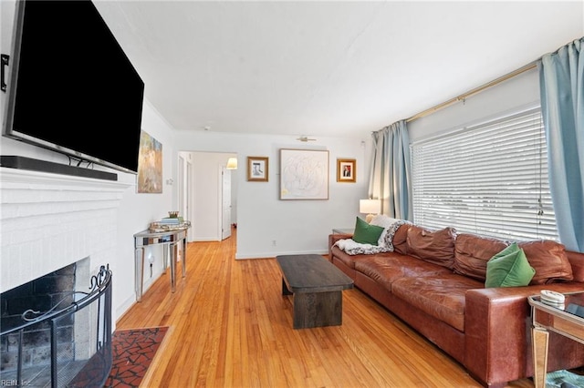 living room featuring a fireplace and light wood-type flooring