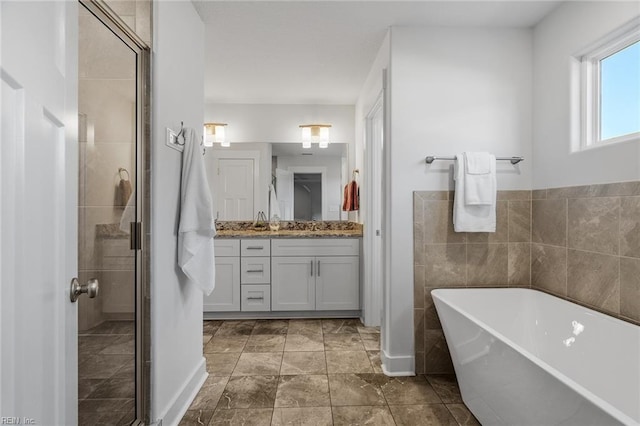 bathroom featuring independent shower and bath, vanity, and tile walls