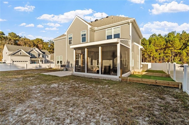 back of property featuring a patio, a sunroom, and a lawn