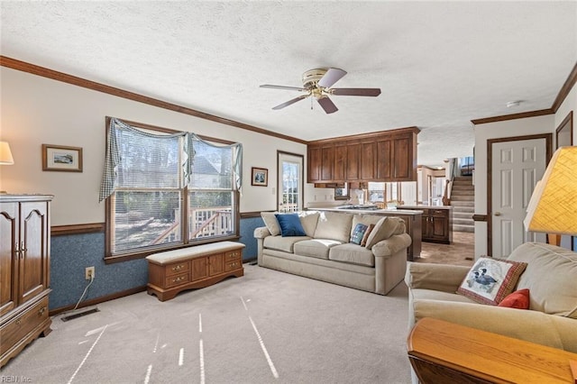 living room featuring crown molding, light carpet, ceiling fan, and a textured ceiling