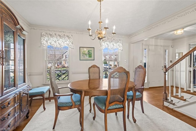 dining room with ornamental molding, a wealth of natural light, hardwood / wood-style floors, and a chandelier