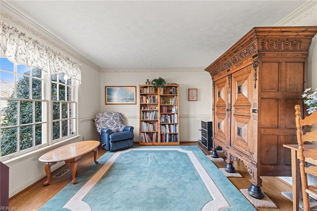 living area featuring ornamental molding, a textured ceiling, and light wood-type flooring