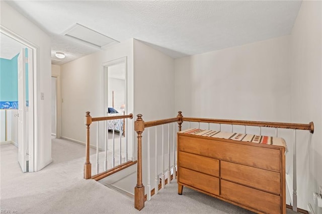 corridor featuring light colored carpet and a textured ceiling