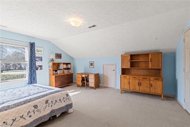 bedroom featuring lofted ceiling, light carpet, and a textured ceiling