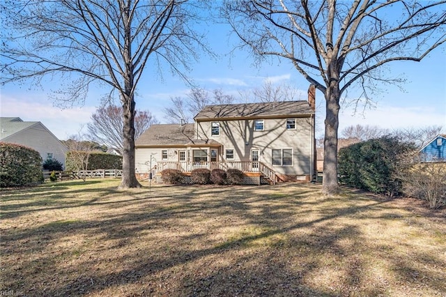 rear view of house with a yard and a deck