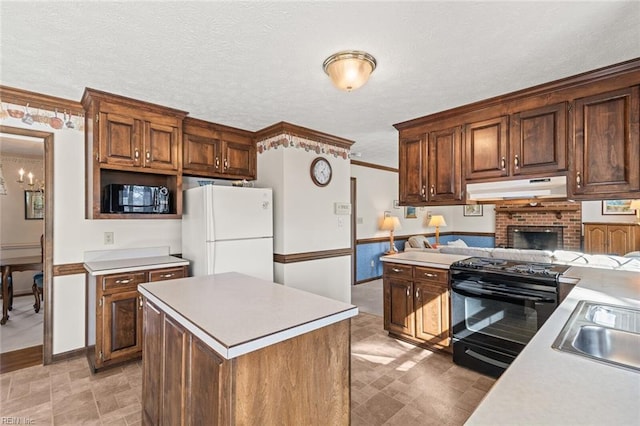 kitchen featuring a kitchen island, sink, black appliances, crown molding, and a textured ceiling