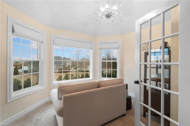 interior space with a notable chandelier, french doors, and carpet