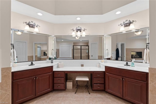 bathroom featuring a multi sided fireplace, vanity, tile patterned flooring, and a shower with door