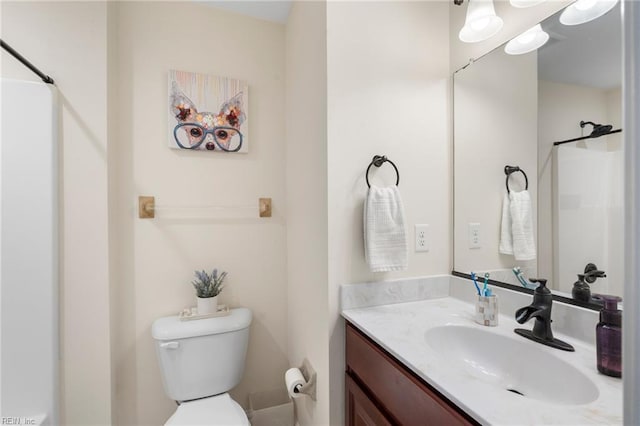 bathroom with vanity, toilet, and a shower