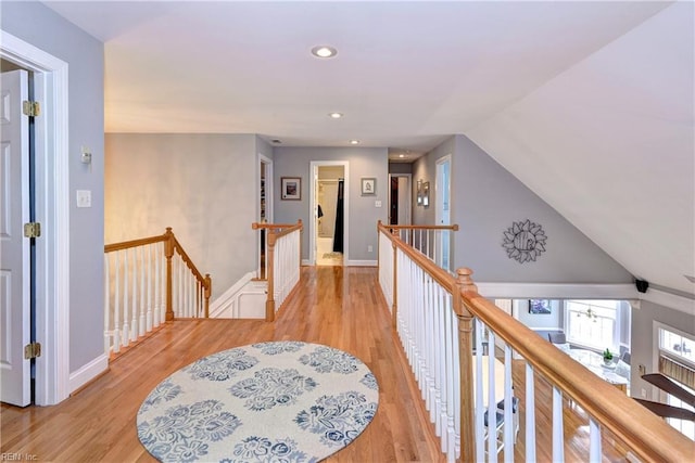 hallway featuring vaulted ceiling and light hardwood / wood-style floors