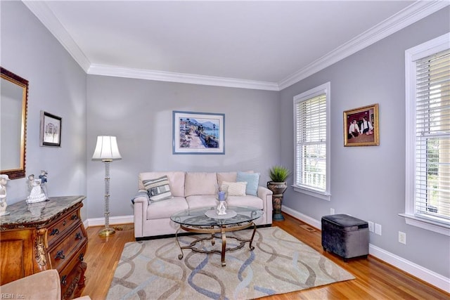 living room with light hardwood / wood-style flooring, crown molding, and plenty of natural light