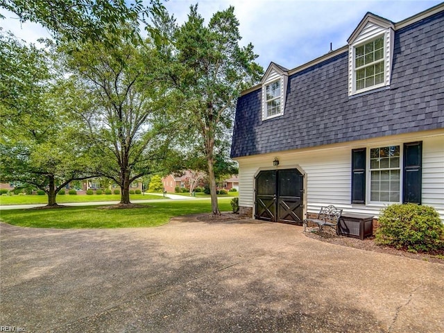 view of side of property featuring a garage and a yard