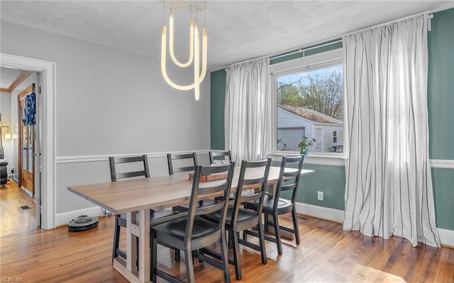 dining area with an inviting chandelier and wood-type flooring