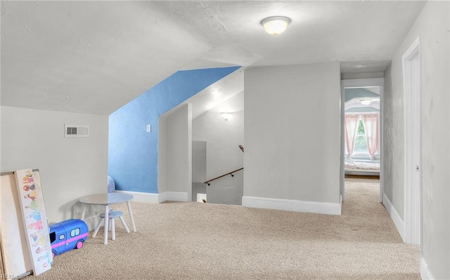 playroom with vaulted ceiling and light colored carpet