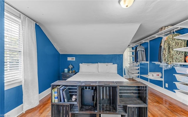 bedroom featuring lofted ceiling and hardwood / wood-style floors