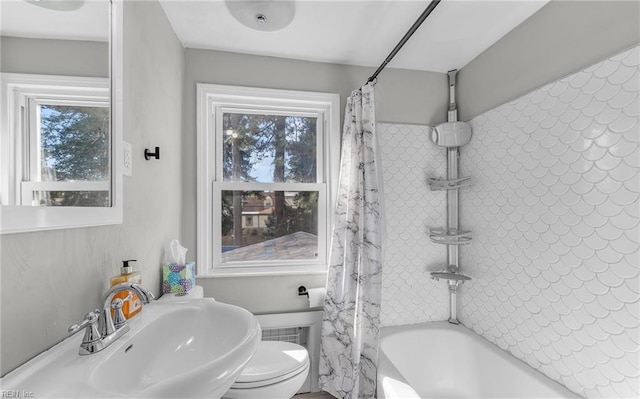 full bathroom with shower / bathtub combination with curtain, sink, plenty of natural light, and toilet