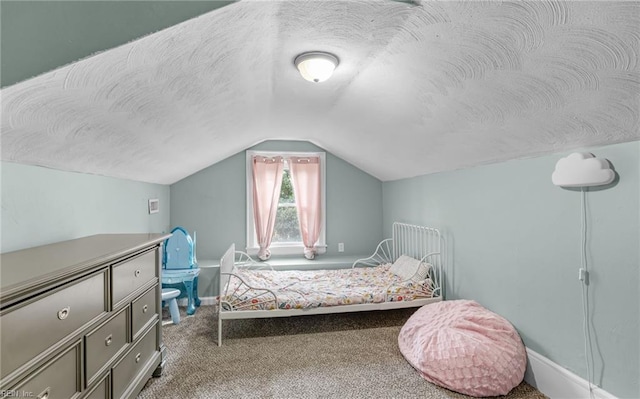 bedroom featuring lofted ceiling, carpet floors, and a textured ceiling