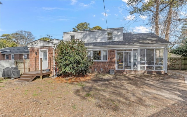 rear view of house featuring a sunroom