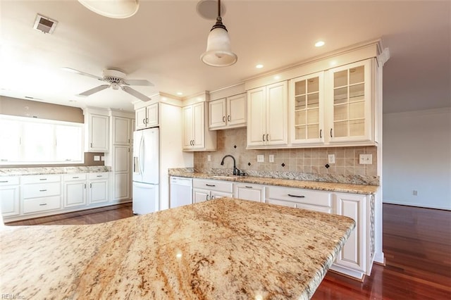 kitchen with white cabinetry, sink, decorative backsplash, hanging light fixtures, and white appliances