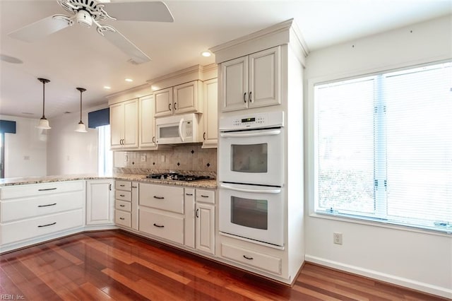 kitchen featuring tasteful backsplash, decorative light fixtures, dark hardwood / wood-style floors, kitchen peninsula, and white appliances