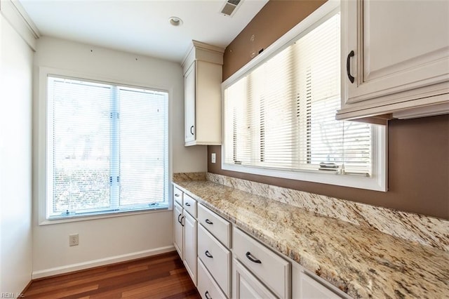 kitchen featuring white cabinetry, light stone countertops, and dark hardwood / wood-style floors