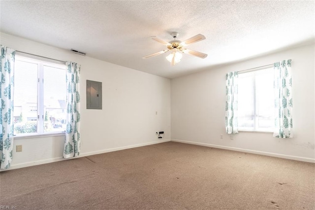 carpeted spare room featuring ceiling fan, electric panel, and a textured ceiling