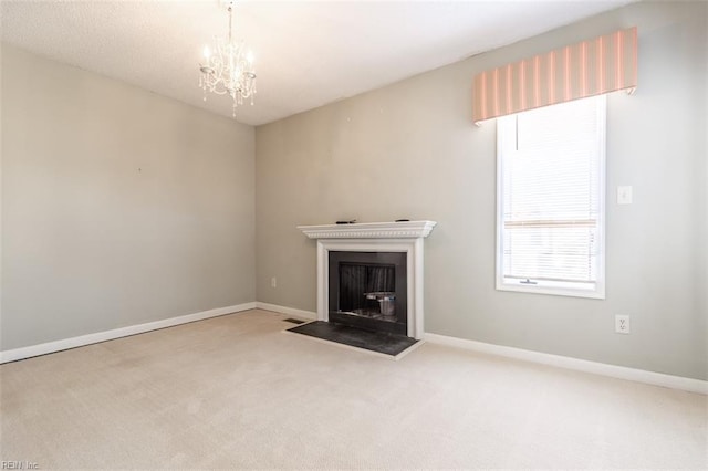 unfurnished living room featuring a chandelier and carpet