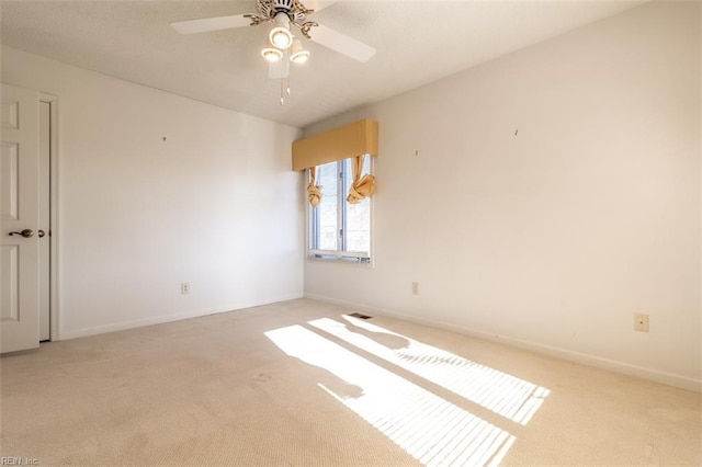 carpeted spare room with ceiling fan