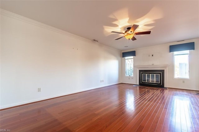 unfurnished living room with crown molding, ceiling fan, plenty of natural light, and dark hardwood / wood-style flooring