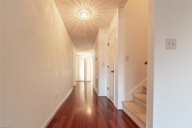 hallway featuring dark hardwood / wood-style floors and a textured ceiling