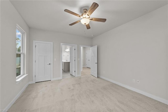 unfurnished bedroom with light colored carpet, ceiling fan, and ensuite bathroom