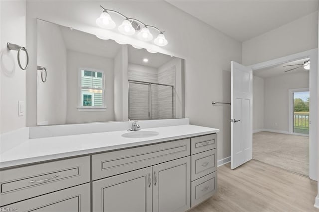 bathroom featuring vanity, wood-type flooring, ceiling fan, and walk in shower