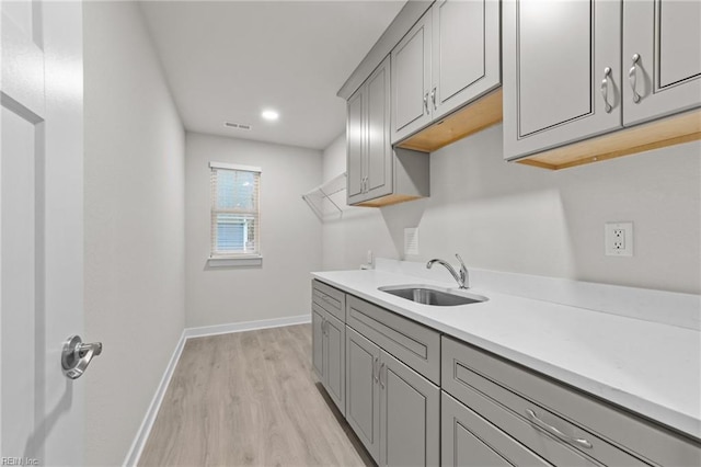 laundry room featuring sink and light wood-type flooring