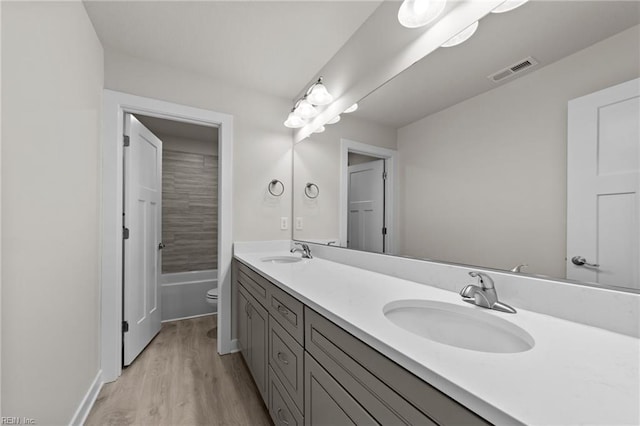 full bathroom with vanity, wood-type flooring,  shower combination, and toilet