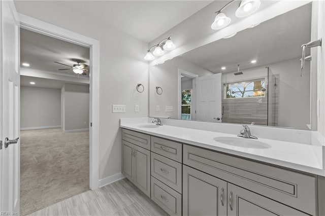 bathroom with walk in shower, ceiling fan, and vanity