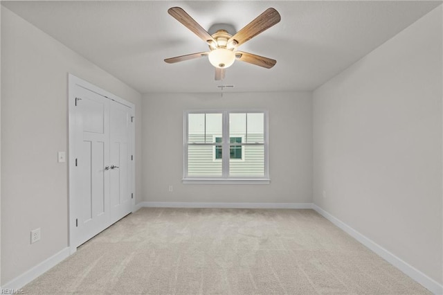 carpeted spare room with ceiling fan