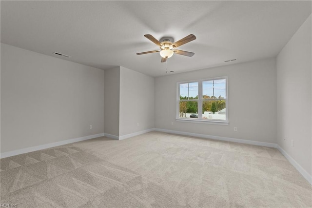 spare room featuring light colored carpet and ceiling fan